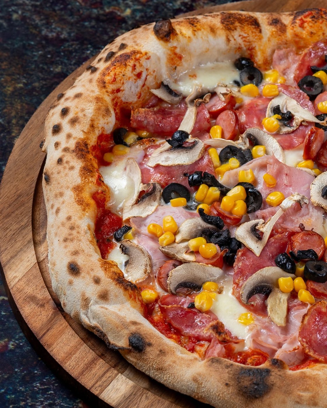 Pizza Capricciosa cu șuncă, salam, ciuperci, porumb și măsline